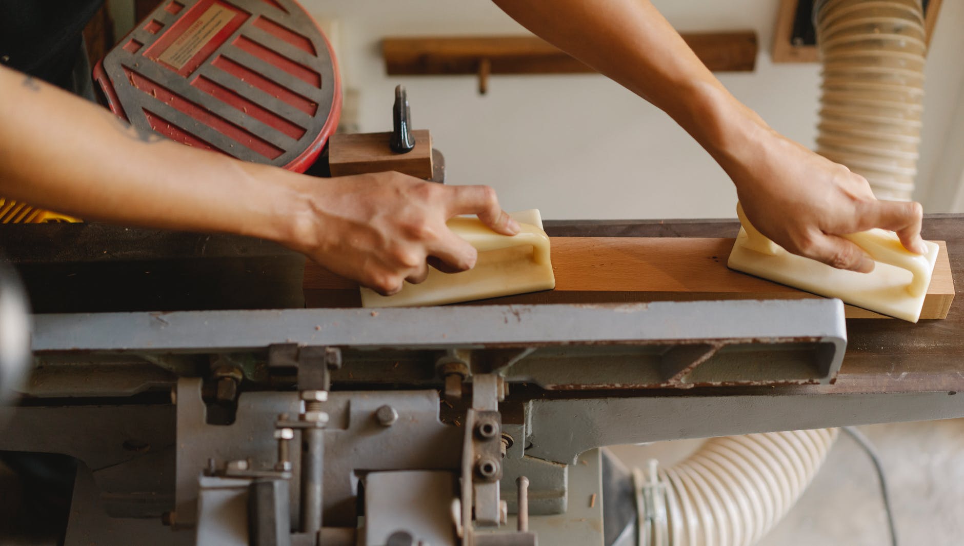 crop artisan flattening lumber on jointer in workshop